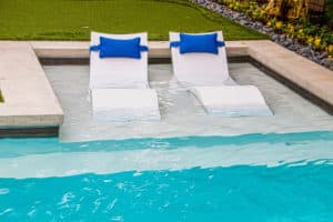 Comfy white Ledge Loungers in shallow end of refreshing blue swimming